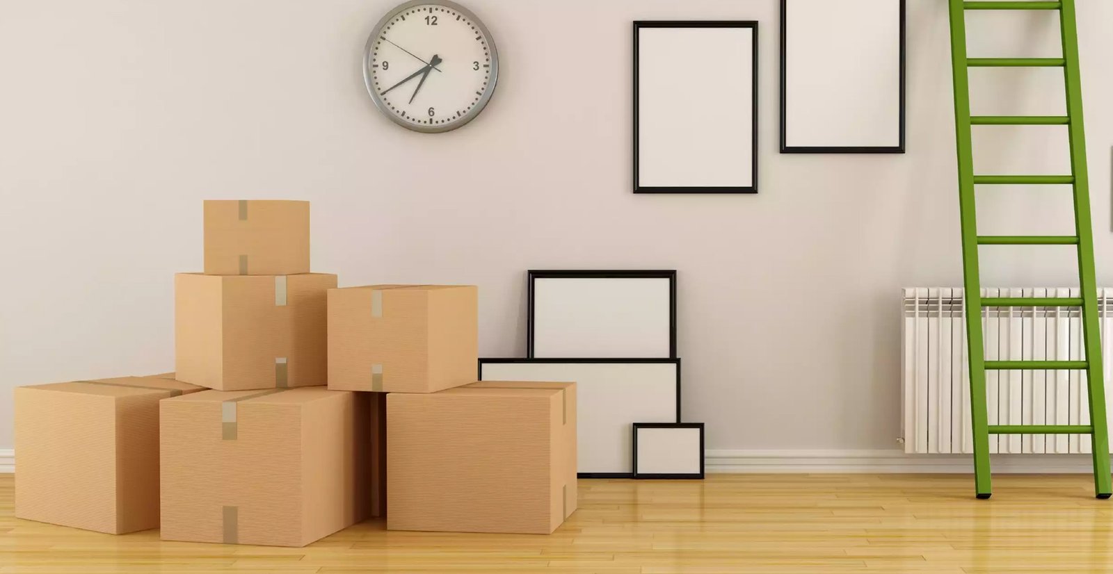 A room being prepared for moving, with a stack of cardboard moving boxes, several empty picture frames leaning against a wall, a wall clock, a white radiator, and a green ladder positioned nearby. The space has light-colored walls and wooden flooring.